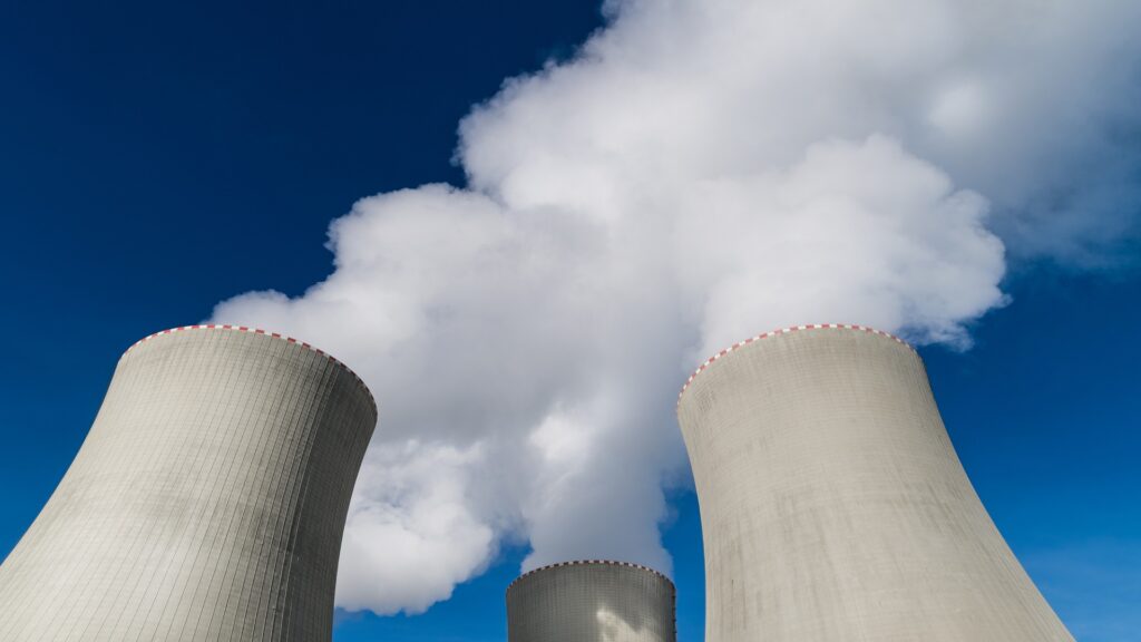 Top detail of large concrete structures removing heat from modern generating station on blue sky background. Eco