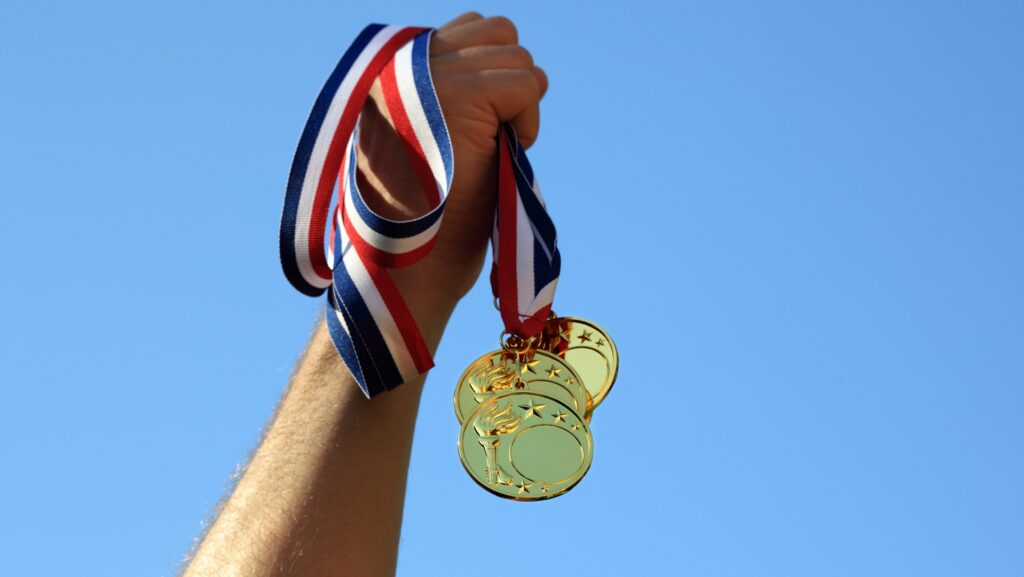 Winning at olympic games, hand holding gold medals