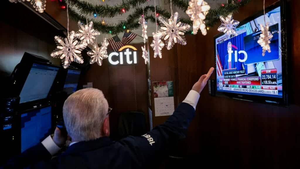 FILE PHOTO: A trader works inside his booth as a screen displays U.S. Federal Reserve Chairperson Jerome Powell's news conference on the floor of the New York Stock Exchange (NYSE) in New York, U.S., December 19, 2018. REUTERS/Brendan McDermid/File Photo