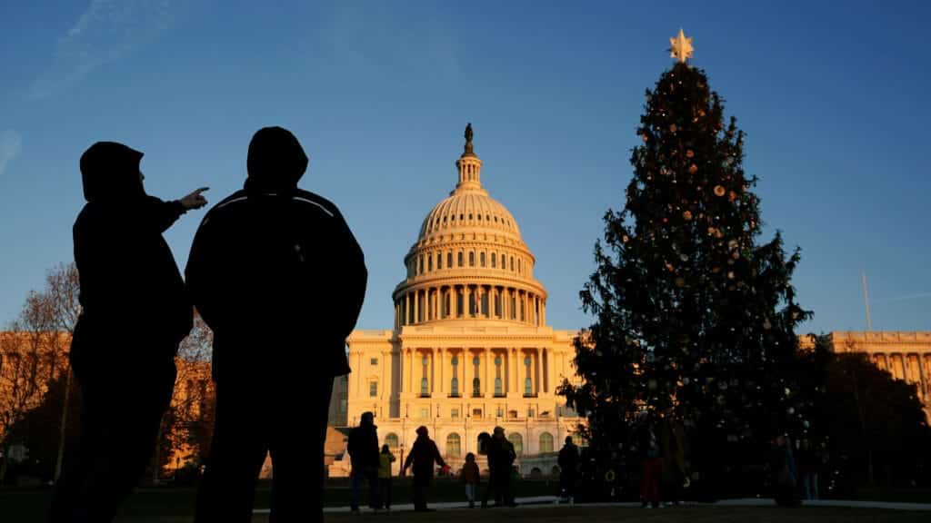 Visitors look up toward the U.S. Capitol Christmas Tree at sunset in Washington, U.S., December 20, 2023. REUTERS/Kevin Lamarque