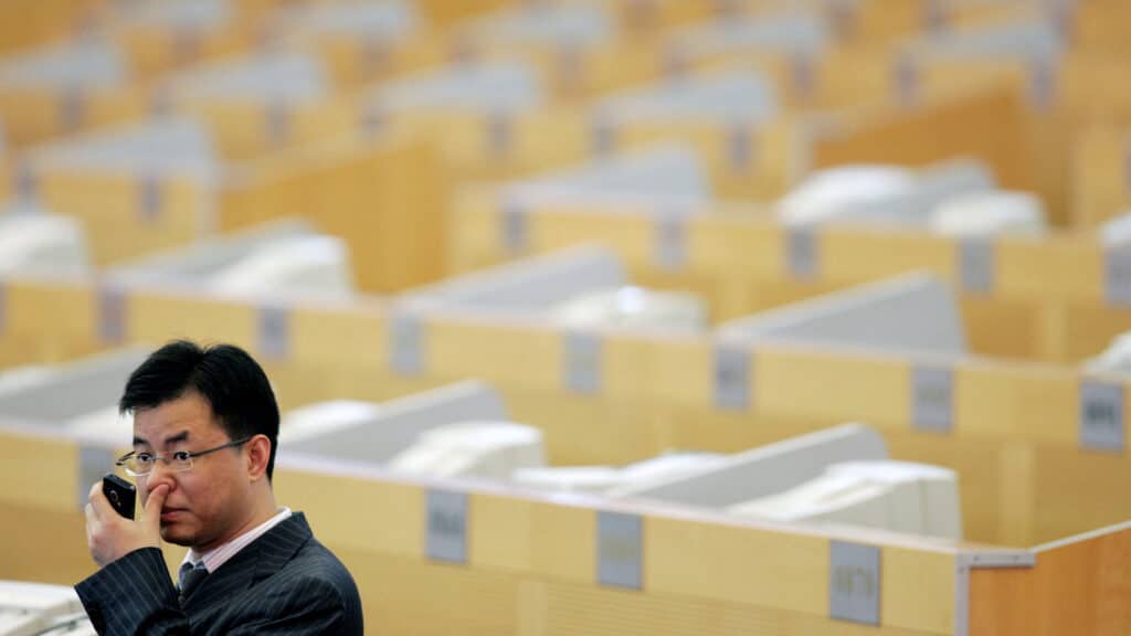 FILE PHOTO: A man stands at the Shanghai Stock Exchange in Lujiazui Financial Area in Shanghai September 25, 2007. REUTERS/Aly Song (CHINA)/File Photo