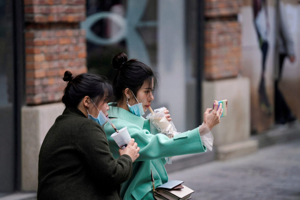 FILE PHOTO: Women with face masks enjoy their bubble tea at a shopping complex in Wuhan, Hubei province, the epicentre of China's coronavirus disease (COVID-19) outbreak, March 31, 2020.  REUTERS/Aly Song/File Photo