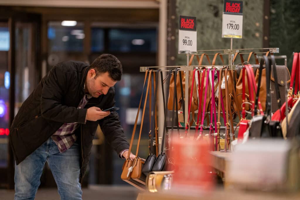 FILE PHOTO: A shopper uses a phone at Macy's department store during Black Friday shopping in Manhattan in New York City, New York, U.S., November 24, 2023. REUTERS/David Dee Delgado/File Photo