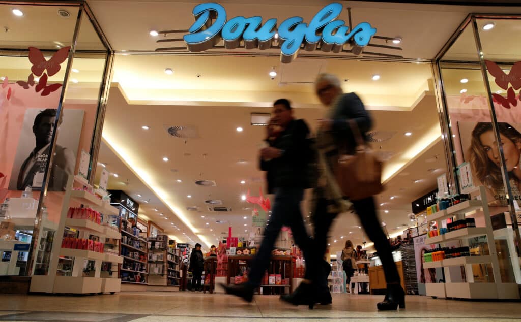 FILE PHOTO: People pass in front of Douglas Holding AG perfume shop at a shopping mall in Magdeburg, Germany, March 11, 2016.     REUTERS/Fabrizio Bensch/File Photo