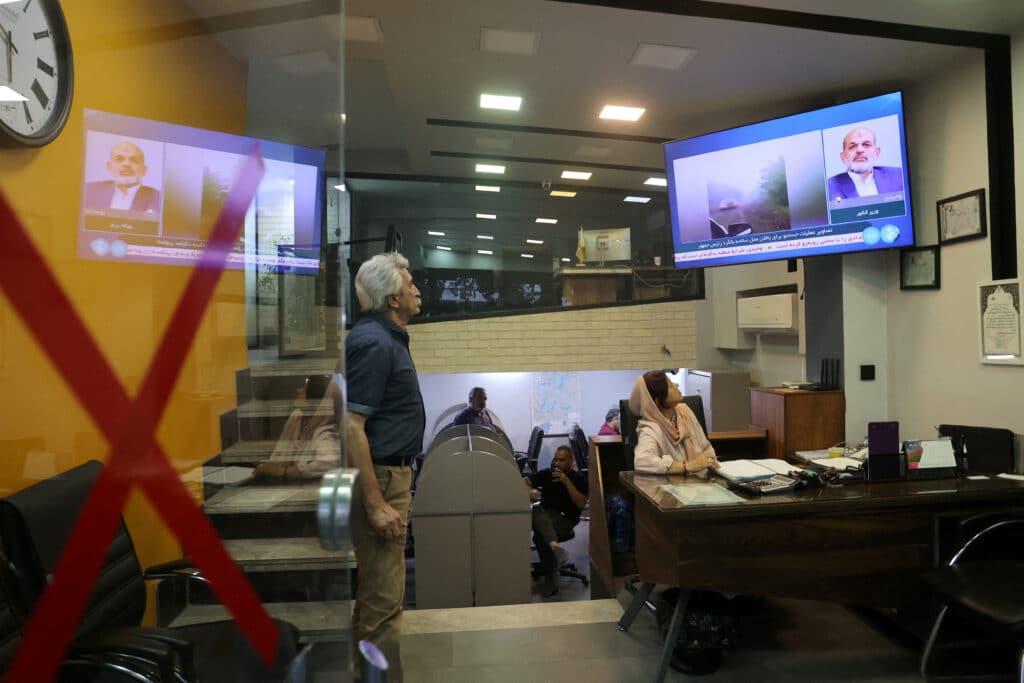 People follow the news of a crash of a helicopter carrying Iran's President Ebrahim Raisi, on a TV in a shop in Tehran, Iran, May 19, 2024. Majid Asgaripour/WANA (West Asia News Agency)via REUTERS ATTENTION EDITORS - THIS PICTURE WAS PROVIDED BY A THIRD PARTY.
