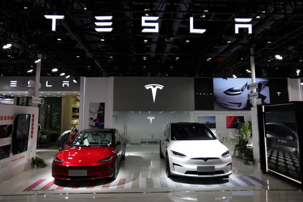 FILE PHOTO: A staff member looks at Tesla's new Model 3 sedan displayed next to Model X SUV at the China International Fair for Trade in Services (CIFTIS) in Beijing, China, September 2, 2023. REUTERS/Florence Lo/File Photo