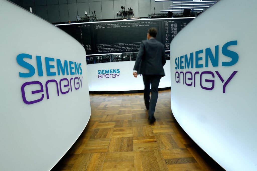 FILE PHOTO: A trader walks next to Siemens Energy AG logos during Siemens Energy's initial public offering (IPO) at the Frankfurt Stock Exchange in Frankfurt, Germany, September 28, 2020.     REUTERS/Ralph Orlowski/File Photo