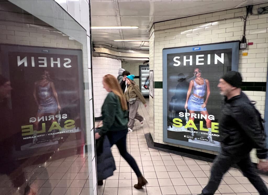 FILE PHOTO: FILE PHOTO: People walk past an advertisement for Shein, March 8, 2024 in London, Britain. REUTERS/Suzanne Plunkett/File Photo/File Photo