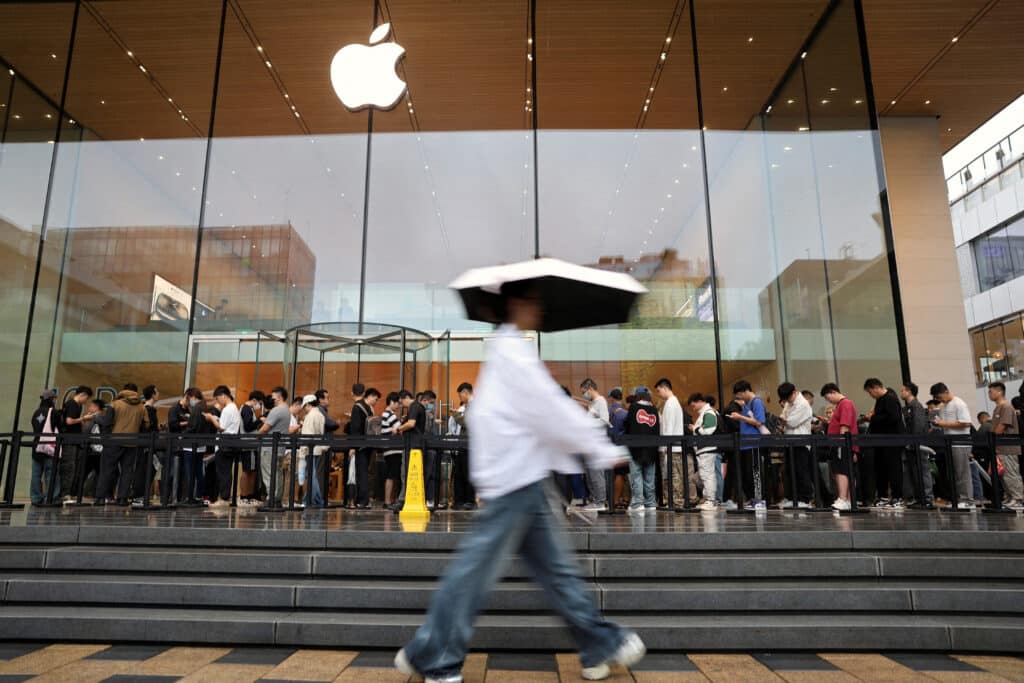FILE PHOTO: People line up outside an Apple store on a rainy day as the new iPhone 16 series smartphones go on sale, in Beijing, China, Sept. 20, 2024. REUTERS/Florence Lo/File Photo