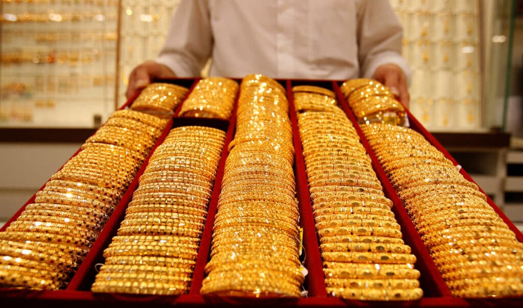FILE PHOTO: A shop attendant displays a tray of gold bangles for the camera at a jewellery store in Singapore, September 18, 2008. REUTERS/Vivek Prakash (SINGAPORE)/File Photo