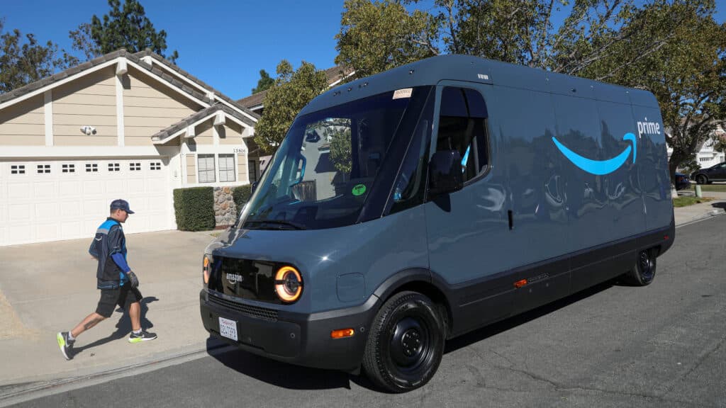 FILE PHOTO: Driver David Gonzalez walks back to his truck after delivery in an Amazon Rivian Electric truck in Poway, California, U.S., November 16, 2022. REUTERS/Sandy Huffaker/File Photo