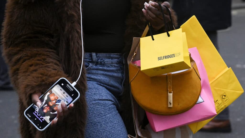 A woman walks with shopping bags on Oxford Street during Boxing Day sales, in London, Britain, December 26, 2024.  REUTERS/Jaimi Joy