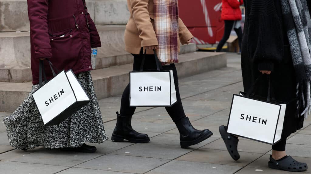 FILE PHOTO: Shoppers carry bags with promotional merchandise as they visit fashion retailer Shein's Christmas bus tour, in Manchester, Britain, December 13, 2024. REUTERS/Temilade Adelaja/File Photo