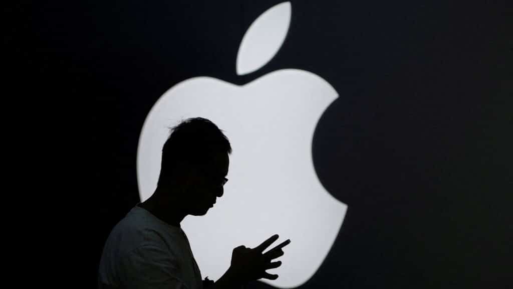 FILE PHOTO: A man check his phone near an Apple logo outside its store in Shanghai, China September 13, 2023. REUTERS/Aly Song/File Photo