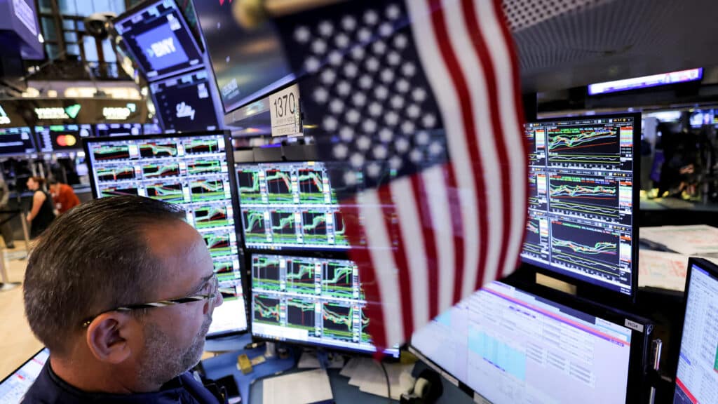 FILE PHOTO: A trader works at the New York Stock Exchange (NYSE) next to a U.S. flag, after Republican Donald Trump won the U.S. presidential election, in New York City, U.S., November 6, 2024. REUTERS/Andrew Kelly/File Photo