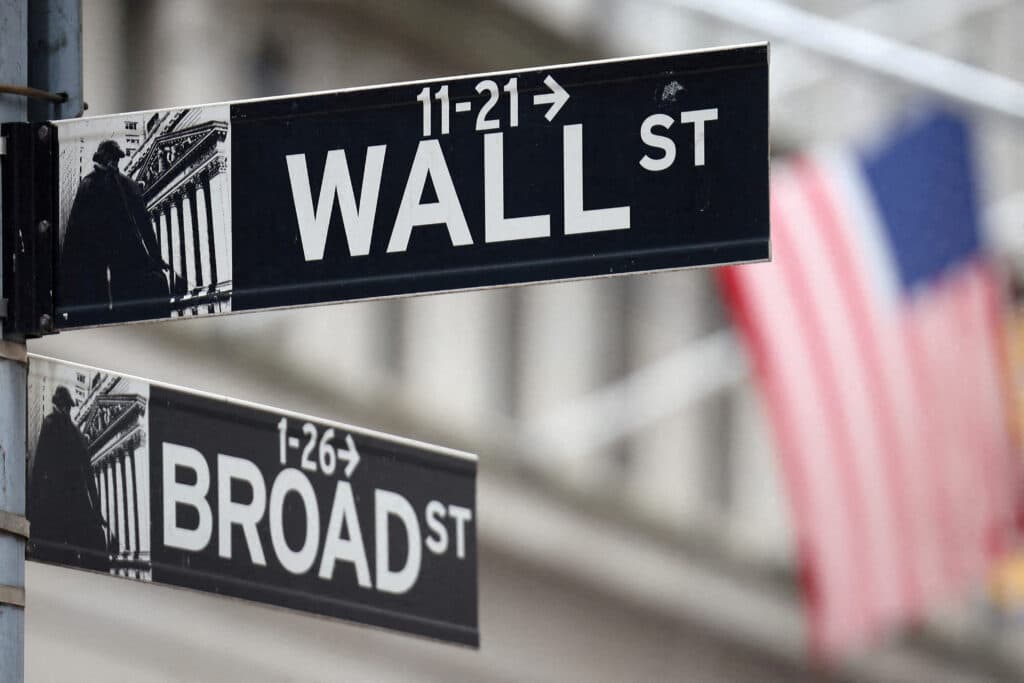 FILE PHOTO: A Wall Street sign hangs in front of a U.S. Flag outside the New York Stock Exchange (NYSE) before the Federal Reserve announcement in New York City, U.S., September 18, 2024. REUTERS/Andrew Kelly/File Photo