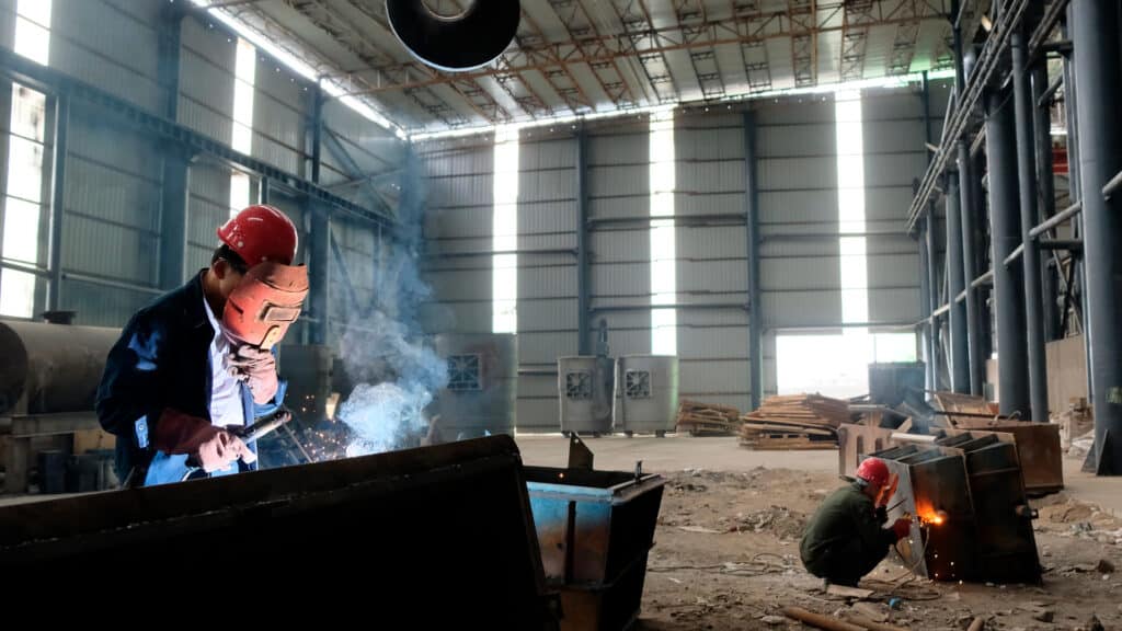 Рабочие в цеху сваривают металлические изделия