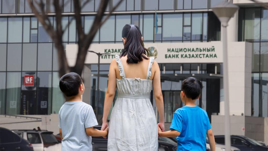 Мать и дети перед зданием Нацбанка Казахстана 
