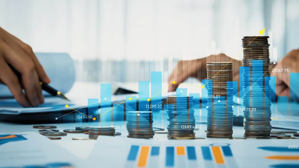 Coin stack with digital graphic indicator symbolizing business investment and economic growth. Businessman doing financial planning to achieve financial goal and contribute to profit. Shrewd