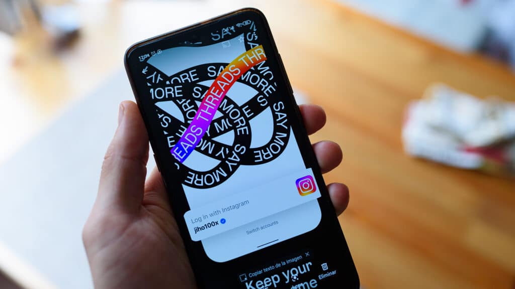 The app Threads from Meta is seen on the display of a mobile phone in the hand of a person