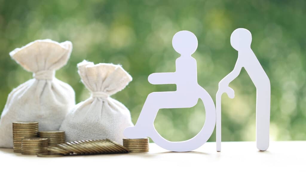 Mutual fund,Senior and wheelchair user with money bag on natural green background, Save money for handicapped person and pension retirement concept