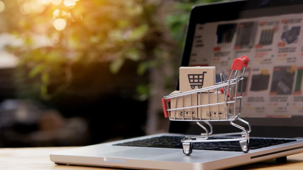 Shopping online. cardboard box with a shopping cart logo in a trolley on laptop keyboard. Shopping service on The online web. offers home delivery