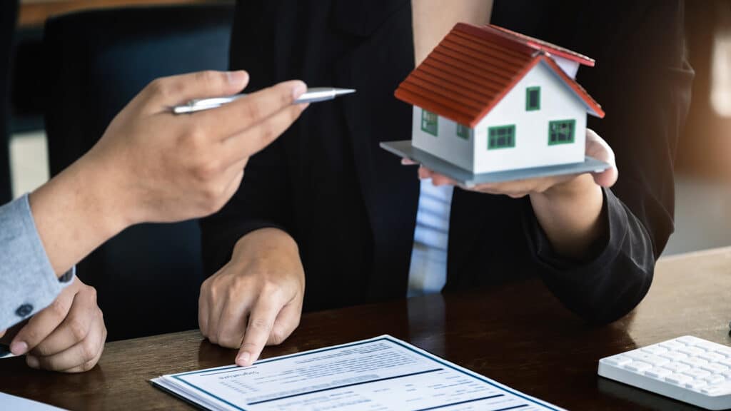 Loan signing concept, refinancing, home and land purchase, rental accommodation, female real estate agent or bank employee pointing to a contract or agreement with a male client to  to Buy a dwelling